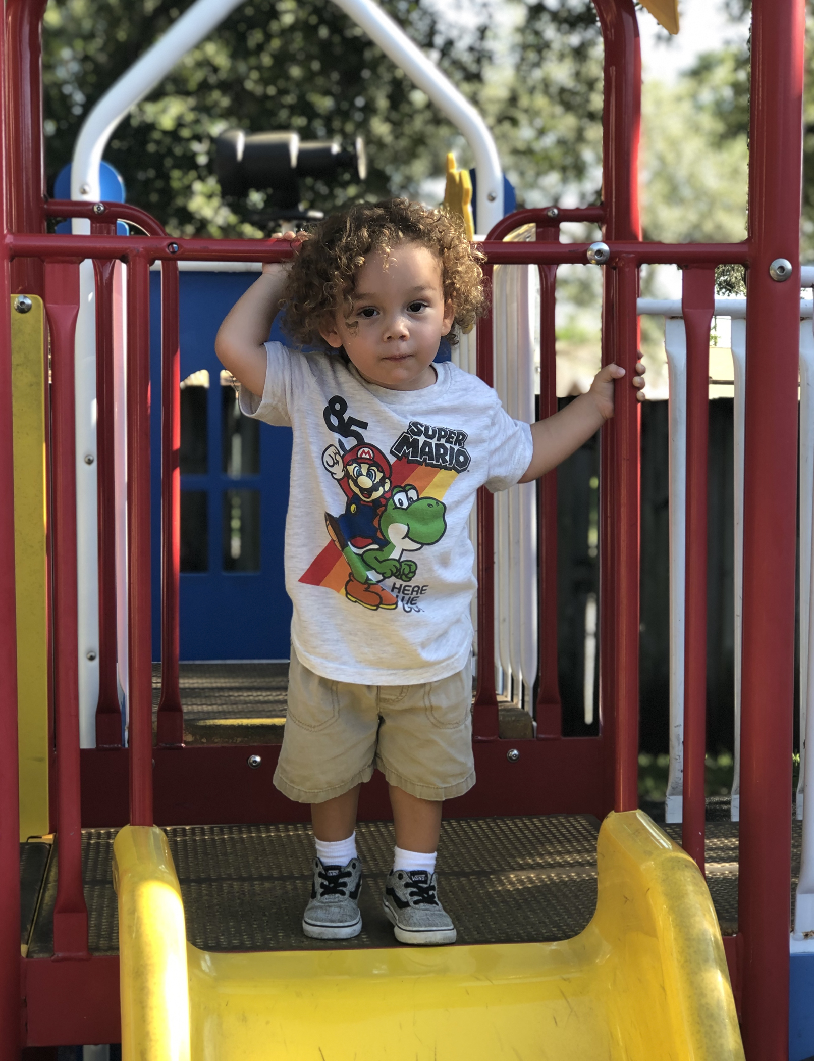 holycross-kid-standing-at-top-of-playground-slide
